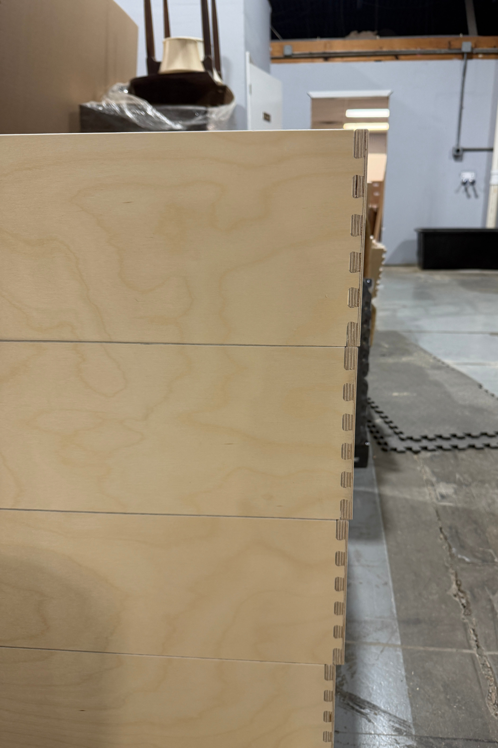 stacked baltic birch drawer boxes with dovetail joints in workshop showing precision construction