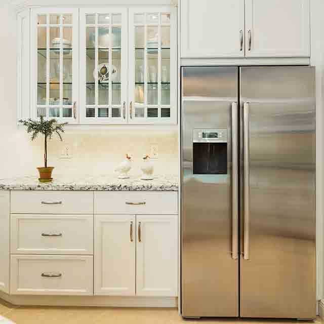 A white kitchen with glass front cabinets