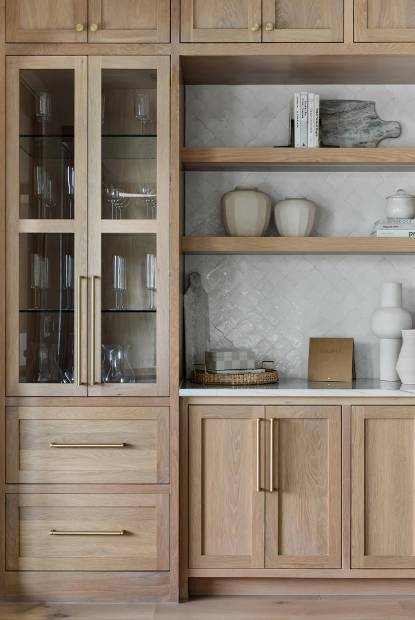 White Oak Unfinished Cabinet Doors with Open Shelving in Organic Modern Kitchen White Oak unfinished cabinet doors with natural wood grain, glass cabinet inserts, and floating shelves in a modern organic kitchen design.