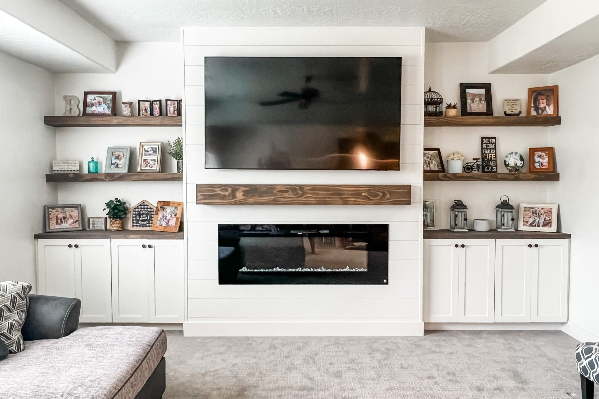 White Shaker Cabinet Doors with Floating Shelves White shaker cabinet doors with floating wood shelves in a custom fireplace entertainment center built-in.