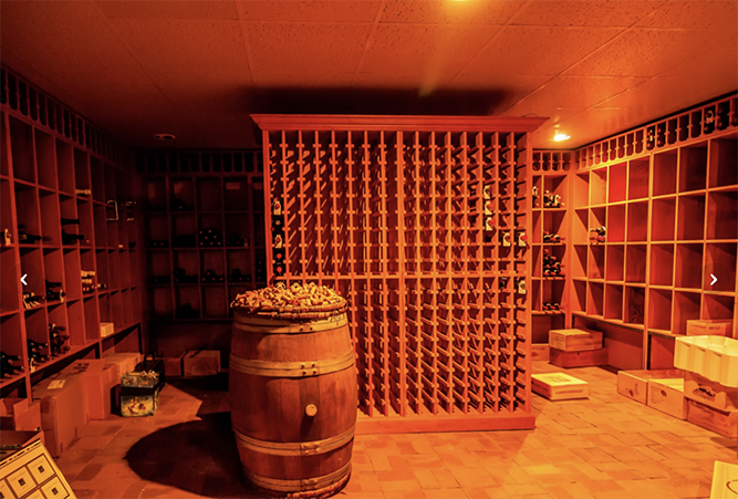 A wine cellar with shelves and a barrel.